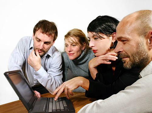 4 business people looking at a laptop